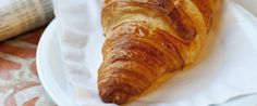 a croissant sitting on top of a white plate