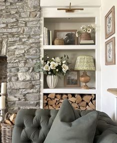 a living room filled with furniture next to a fire place and stone fireplace mantel