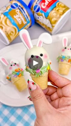 a person holding an ice cream cone with some bunny bunnies on top of it