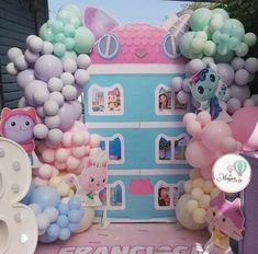 there are many balloons and decorations on the table in front of this house that says princess