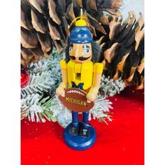 a football player ornament sitting on top of a table next to pine cones