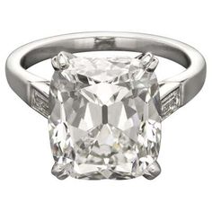 a cushion cut diamond ring with channeled shoulders and an old european style setting in white gold