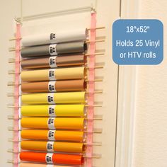 there is a rack with different colors of vinyl rolls hanging from it's sides