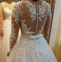 the back of a bride's wedding dress in front of a mirror