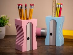 two pencils are in the holder on the table next to some pens and pencils