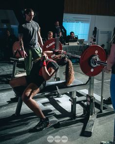 a woman doing squats on a bench with a barbell in front of her