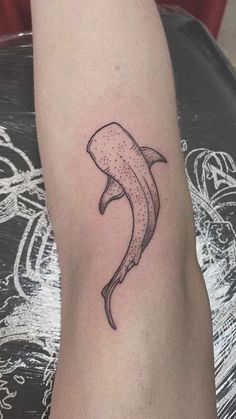 a black and white photo of a banana tattoo on the left arm, with dots in it