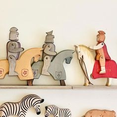 three wooden toy animals sitting on top of shelves