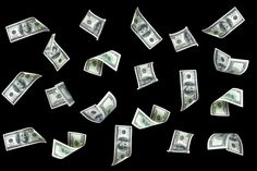 several hundred dollar bills falling down into the air on a black background with space for text