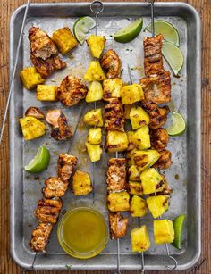 chicken skewers with pineapple and avocado sauce on a baking sheet