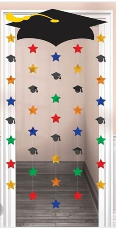 graduation decorations hanging from the ceiling in a room with white walls and wooden flooring