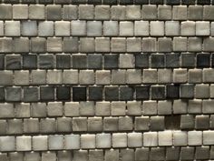 a gray and white tile wall with small squares