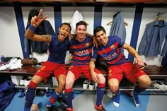 two soccer players sitting on a bench with their arms around each other and making the peace sign