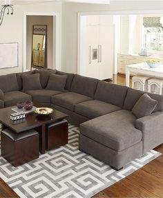 a living room with a large sectional couch and coffee table in the middle of it