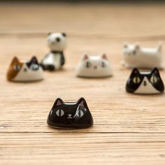 small black and white cat figurines sitting on top of a wooden table