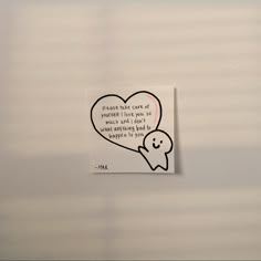 a heart shaped sticker hanging on the side of a wall next to a message