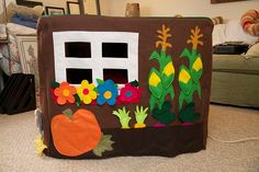 a child's play house made out of felt with flowers and pumpkins on it