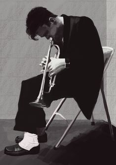 a man sitting in a chair with his head down and holding a trumpet to his face