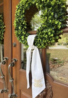 two wreaths are hanging on the front door