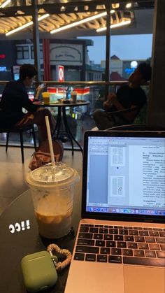 an open laptop computer sitting on top of a table next to a cup of coffee