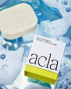 an acla soap bar sitting on top of blue ice with water droplets around it