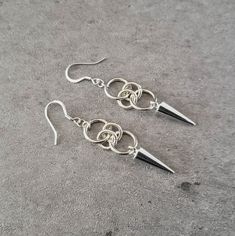 "Add some edgy urban style to your wardrobe with these hoop and spike drop earrings. 💀 DESCRIPTION: This pair of silver drop earrings were created with jump rings and spike charms. The earrings were attached to hypoallergenic stainless steel ear wires. 💀 SIZE & MATERIALS: The spikes measure approximately 7/8\" by 1/4\". They are made from a zinc alloy metal which is lead and nickel free. Overall, the earrings measure 2\" long and the drop is 1/2\". 💀 GIFT GIVING: These silver spike and lo Alternative Earrings, Grunge Earrings, Christmas Jewelry Gift, Trendy Stud Earrings, Edgy Earrings, Hoop Dangle Earrings, Gift Idea For Women, Bracelets Handmade Diy, Alternative Jewelry