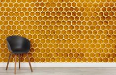 a black chair sitting in front of a wall with honeycombs on it's side