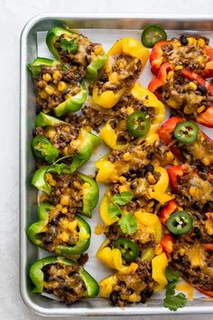 peppers stuffed with ground beef and cheese on a baking sheet