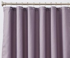 a purple curtain hanging on the side of a window