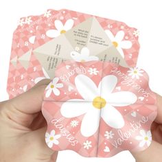 someone is holding up some pink and white cards with daisies on the front, and flowers on the back