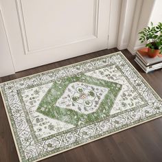 a green and white area rug in front of a door with potted plant on the floor