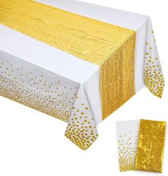 the table cloth is yellow and white with gold dots on it, along with two matching napkins