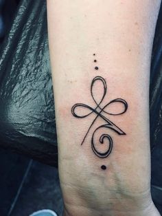 a black and white photo of a tattoo on the wrist with an infinite symbol in it