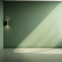 an empty room with a green wall and two lights on the wall, in front of it