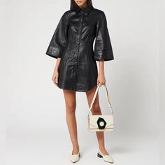 Crafted From Lamb Leather, This Shirt Dress From Ganni Sports A Dramatic Silhouette. Credited With Redefining The Sought After Scandi Style, The Copenhagen Based Label Experiment With Form And Fit In This Collection. Fluted Sleeves Flare Towards The Cuff, While The Tailored Body Cinches The Waist. Cut For A Fitted Form, Darts Extend From The Bustline To The Waist, Accentuating The Curves Of The Body. The Main Feature Of The Dress Is The Stud Button Fastening, The Placket Beginning At The Sharp S Sugar Plum Dress, Ganni Wrap Dress, Ganni Collar, Spring Faux Leather Button-up Dress, Ganni Sequin Dress, Pastel Floral Dress, Ganni Leopard Dress, Ganni Dress, Leather Shirt Dress