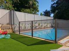 a fenced in swimming pool with artificial grass