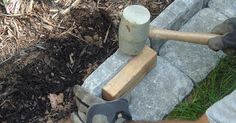 a man is working with cement blocks and hammers on the ground in front of his house