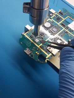 someone is using a drill to fix the motherboard