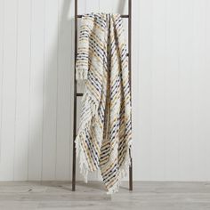 a towel hanging on a rack in front of a white wall with wood planks