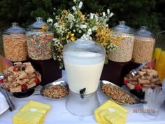 a table topped with lots of food next to jars filled with cereal and other foods