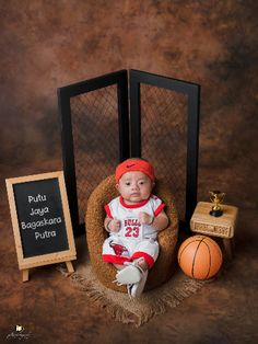 a baby sitting in a chair next to a basketball