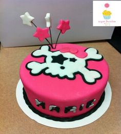 a pink cake with white stars on top and black trim, sitting on a table