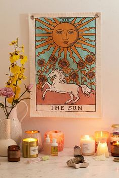 a table topped with candles and vases filled with flowers next to a painting on the wall