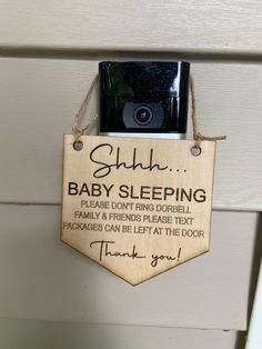 a wooden sign hanging from the side of a door that says, gluh baby sleeping please don't bring dorb