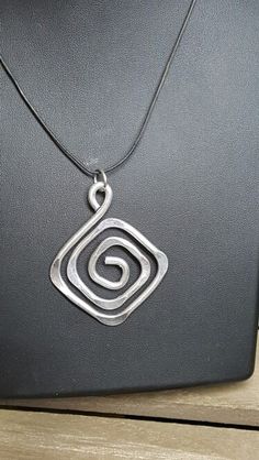 a silver necklace with a spiral design on it