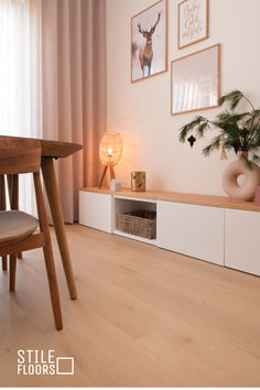 a living room filled with furniture and pictures on the wall next to a wooden table