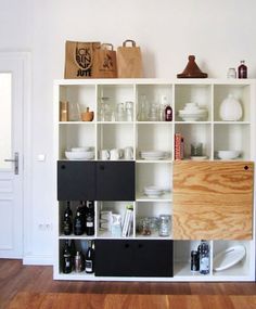 a white book shelf filled with lots of different types of bottles and containers on top of it