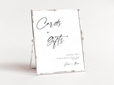 a white sign with the words cards and gifts written in cursive writing on it