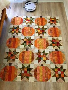 an orange and yellow quilt on the floor