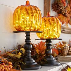 two pumpkin shaped lights sitting on top of a table